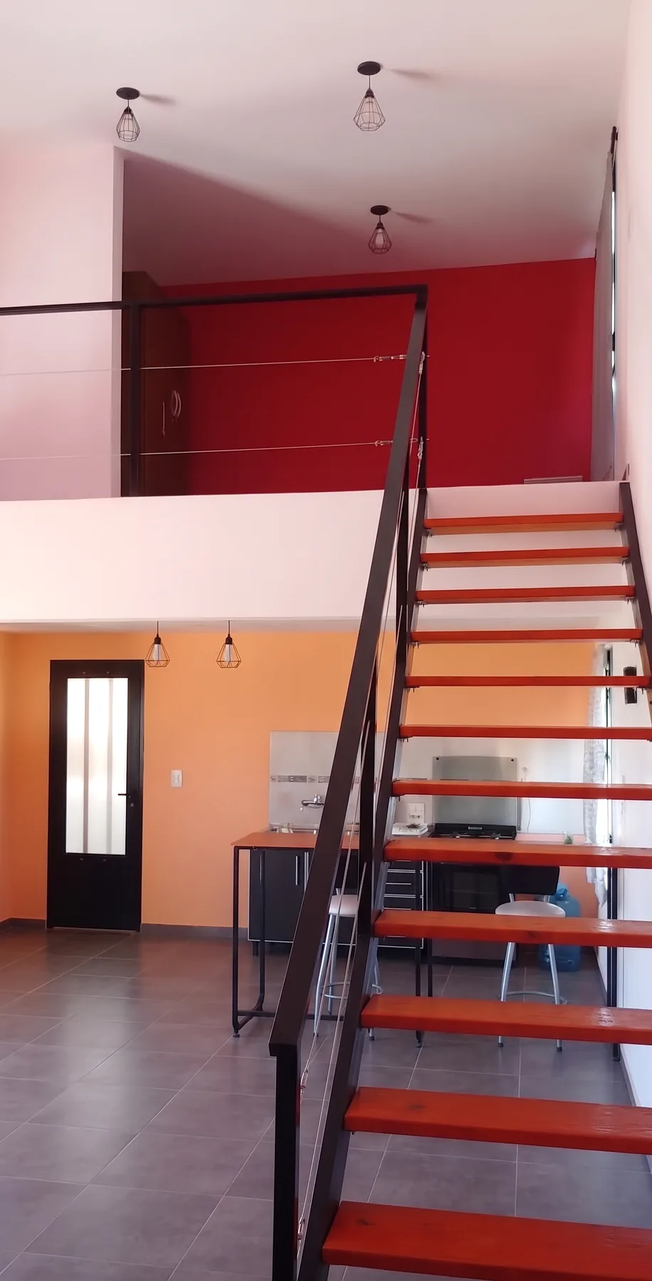 Interior del loft con escalera y entrepiso